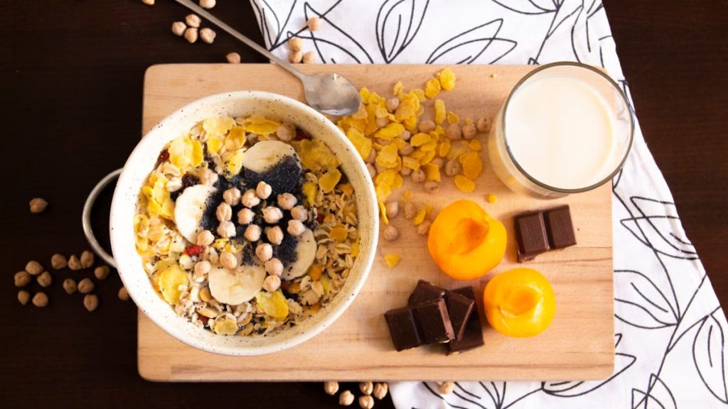 Delicious and healthy breakfast bowl with apricots, cereals, chocolate, and soy milk.